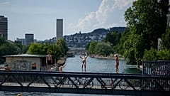 Ein Mann springt während einer Hitzewelle in Zürich in der Schweiz am Freitag, 19. Juni 2026, in die Limmat.