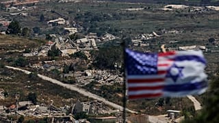 أعلام إسرائيل والولايات المتحدة أمام مبانٍ مدمرة في جنوب لبنان، كما تُرى من شمال إسرائيل، في 21 يونيو 2026.