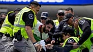 Biztonságiak dulakodnak egy iráni szurkolóval a Belgium - Irán mérkőzésen a kaliforniai Inglewoodban 2026. június 21-én