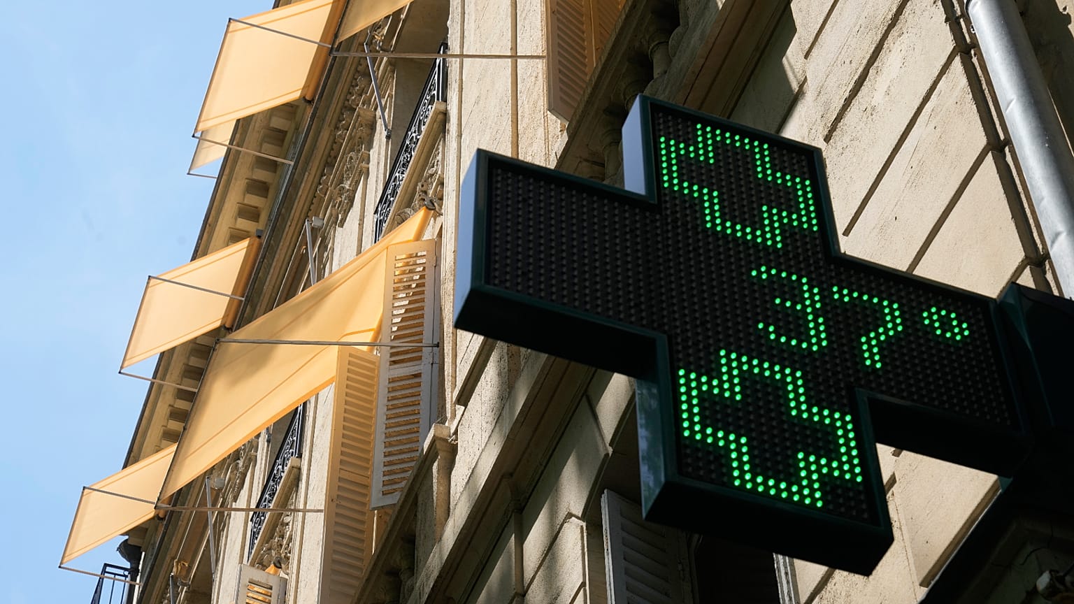 A sign outside a pharmacy displays a temperature of 37 degrees Celsius (98.6 degrees Fahrenheit) in Paris, Sunday, June 21, 2026. 