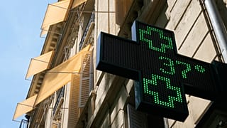 A sign outside a pharmacy displays a temperature of 37 degrees Celsius (98.6 degrees Fahrenheit) in Paris, Sunday, June 21, 2026. 