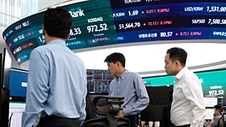 Currency traders work at the foreign exchange dealing room of the Hana Bank headquarters in Seoul, South Korea, Monday, June 22, 2026. 