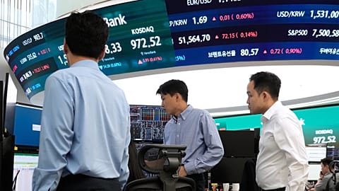 Currency traders work at the foreign exchange dealing room of the Hana Bank headquarters in Seoul, South Korea, Monday, June 22, 2026. 