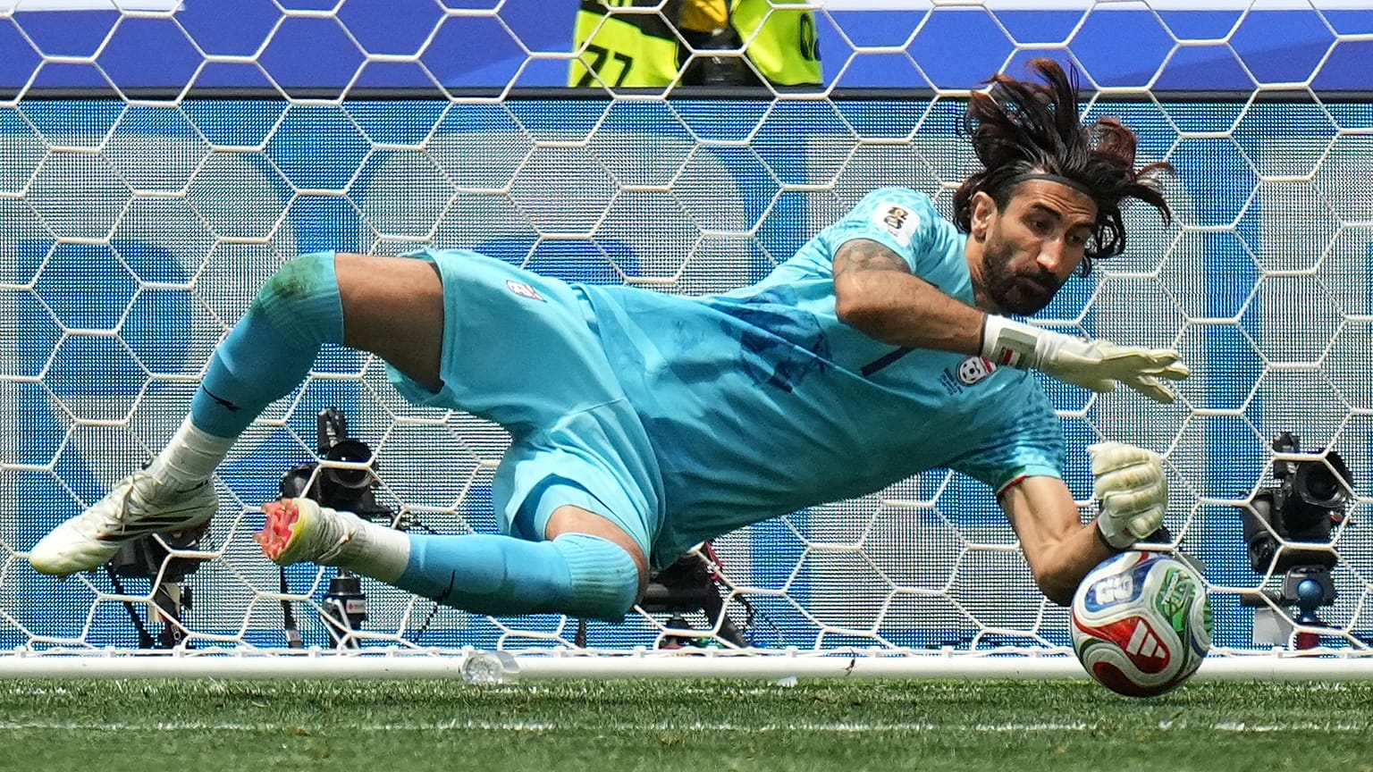 حارس مرمى إيران علي رضا بيرانوند يتصدى لتسديدة خلال مباراة بلجيكا وإيران في كأس العالم، إنغلوود – كاليفورنيا، الأحد 21 يونيو/حزيران 2026.