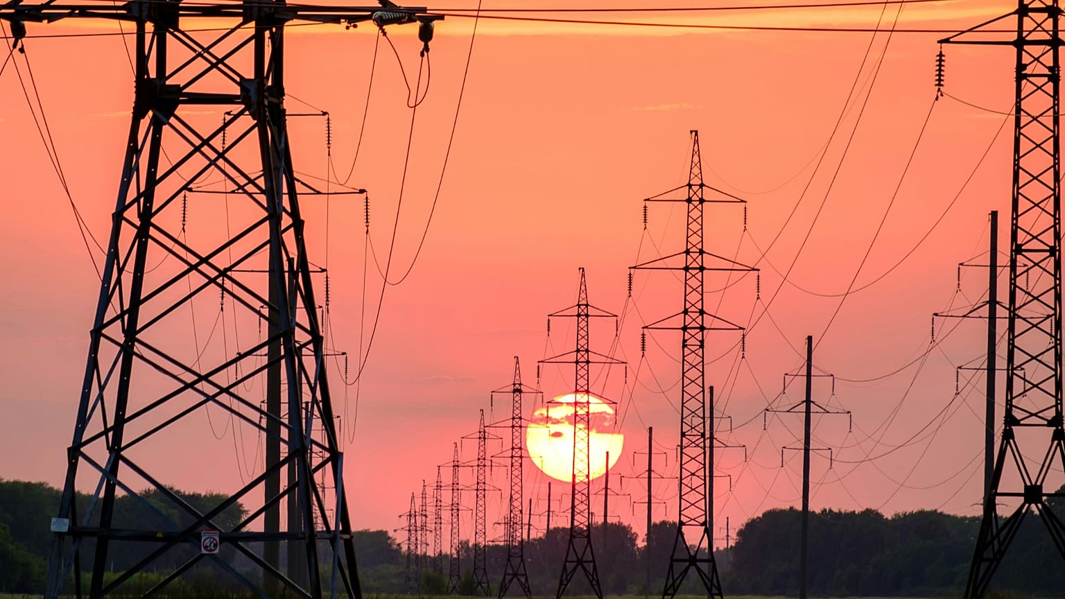Stromleitungen vor einem Sonnenuntergang.