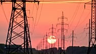 Gün batımı fonunda uzanan elektrik hatları.