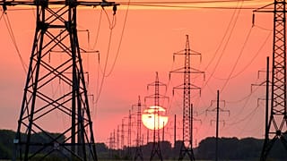 Power lines in front of a sunset.