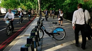 Cyclists and pedestrians walk past a lone hire cycle amongst the empty racks on the Embankment in London, Tuesday, Sept. 7, 2010. 