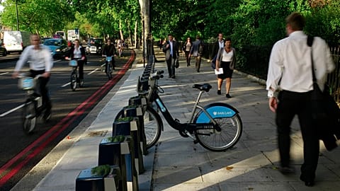 Cyclists and pedestrians walk past a lone hire cycle amongst the empty racks on the Embankment in London, Tuesday, Sept. 7, 2010. 