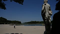 Im Garten von Schloss Versailles schützt sich eine Frau mit einem Schirm vor der Sonne. Eine Hitzewelle treibt die Temperaturen auf über 40 °C.