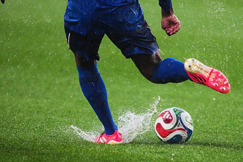 France's Jules Kounde kicks the ball as water splashes on the pitch following a weather delay in the World Cup Group I match against Iraq, Philadelphia, Monday, June 22, 2026