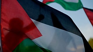 فلسطيني يعيش في قبرص يلوح بالعلم الفلسطيني في ساحة إليفثيريا ليبرتي بالعاصمة نيقوسيا