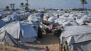 20 يناير/كانون الثاني 2026: أطفال فلسطينيون يسيرون بين خيام في خان يونس جنوب قطاع غزة