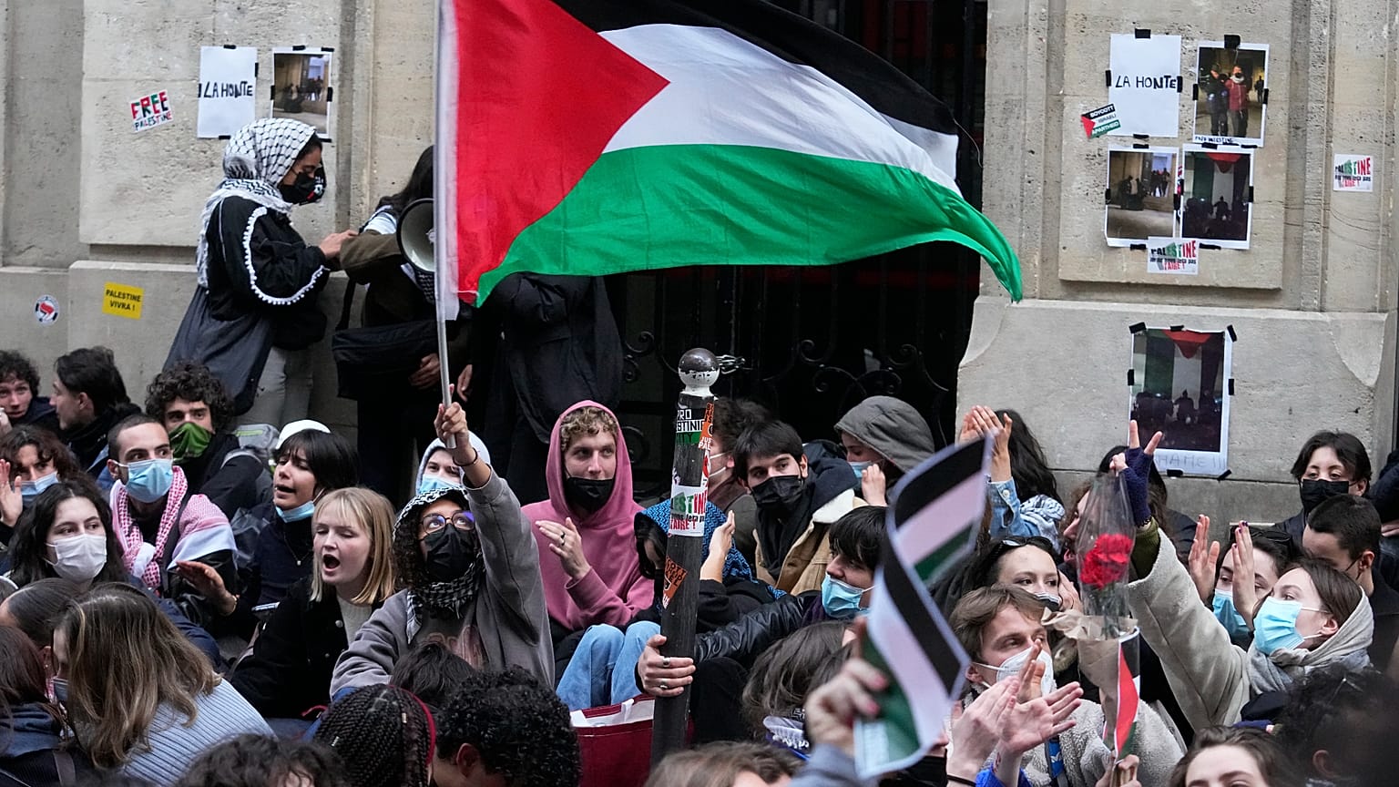 طالب يلوح بالعلم الفلسطيني خارج جامعة ساينس بو في باريس الجمعة 26 أبريل 2024. قام طلاب في باريس، 