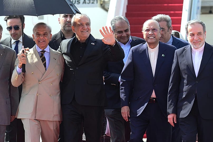 In this photo released by the Pakistan Prime Minister Office, Iran's President Masoud Pezeshkian waves as he walks with Pakistan's President Asif Ali Zardari, June 23, 2026
