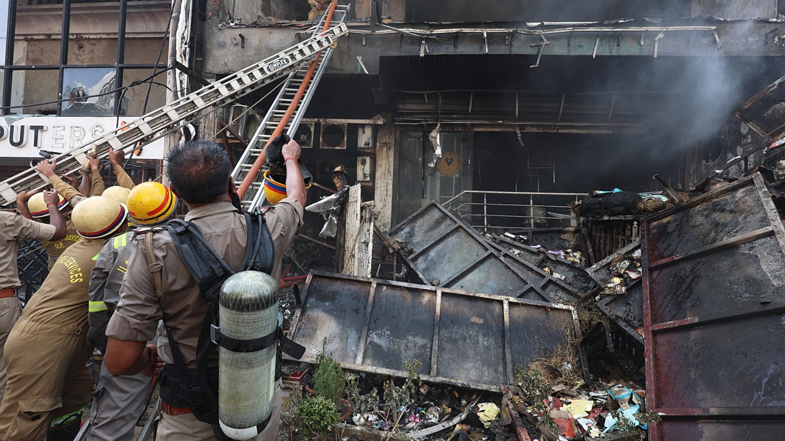 Firefighters work to extinguish a fire that broke out at a commercial building in Lucknow, India