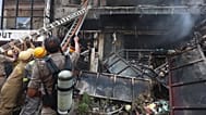 Firefighters work to extinguish a fire that broke out at a commercial building in Lucknow, India