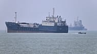 A small motorboat passes anchored vessels in the Strait of Hormuz