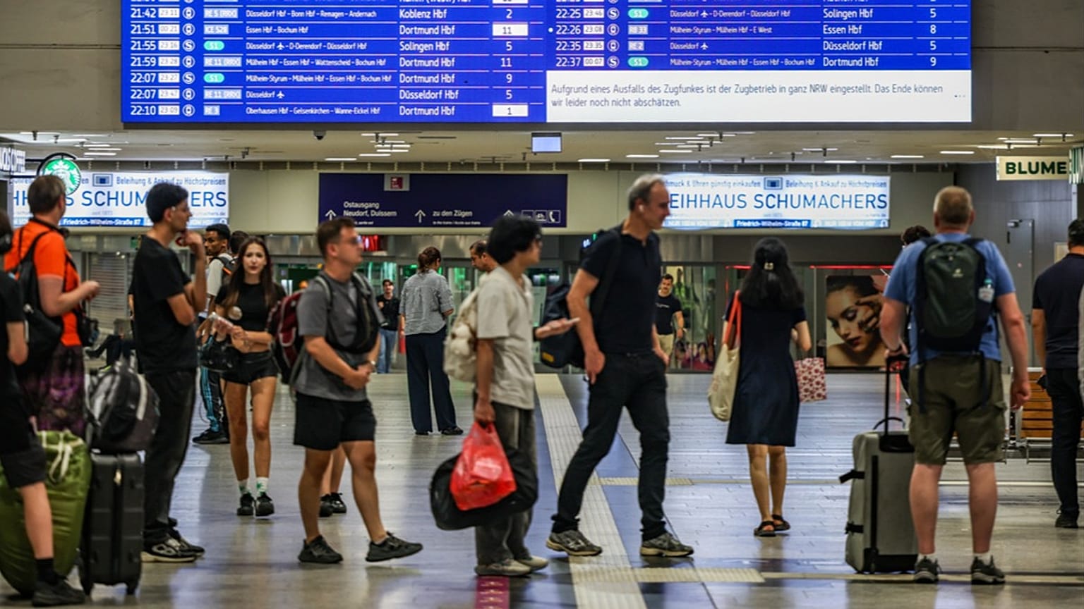 Passengers line up at the DB information desk at the Duisburg train station, Tuesday, June 23, 2026