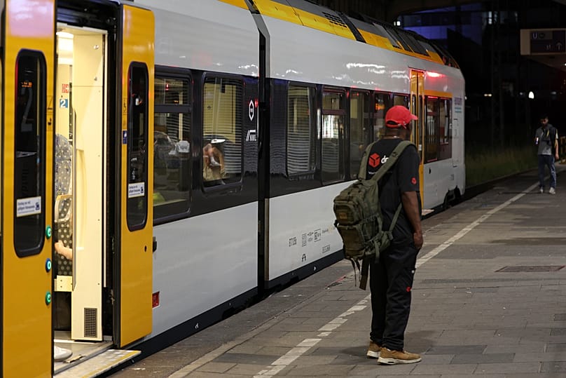 A passenger stands on a platform in front of a train at Duisburg Central Station, Tuesday, June 23, 2026