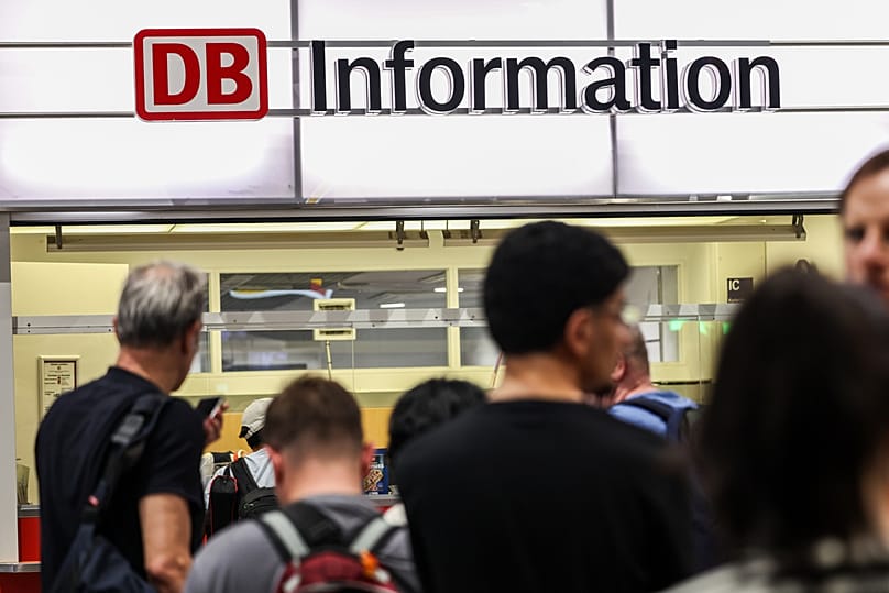 Passengers line up at the DB information desk at the Duisburg train station, Tuesday, June 23, 2026