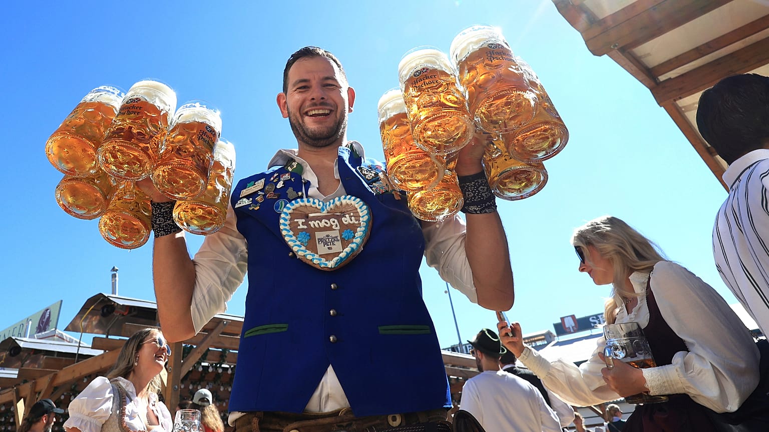 Un cameriere porta boccali di birra nel tendone Hacker nel primo giorno dell’Oktoberfest alla Theresienwiese di Monaco, in Germania, sabato 20 settembre 2025.