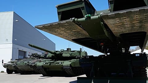 An armoured personnel carrier, a Puma infantry fighting vehicle and a Leopard battle tank produced by pan-European defense company KNDS are displayed in Munich, 22 April 2026