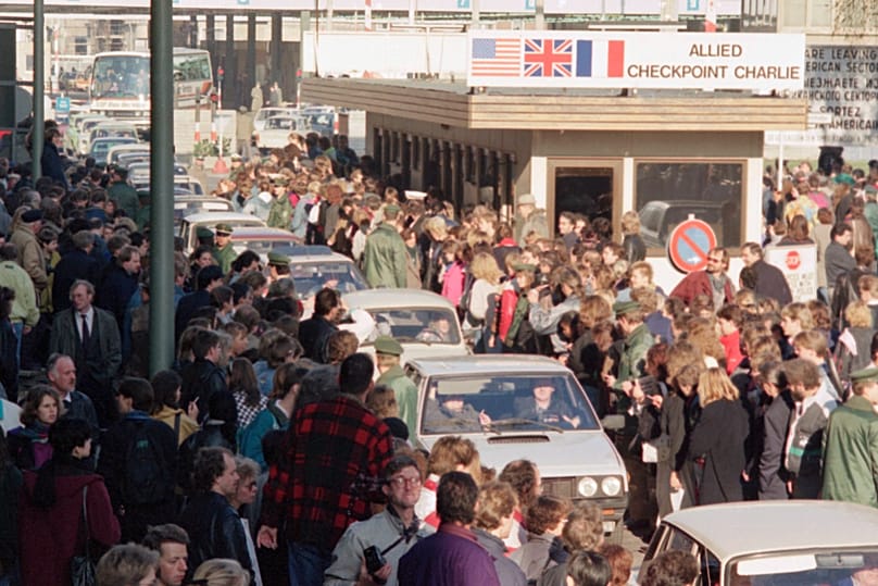 Ostdeutsche Bürger werden von Westberlinern bejubelt, als sie mit ihren Autos den Checkpoint Charlie passieren, um West-Berlin zu besuchen. Archiv: 10. November 1989.
