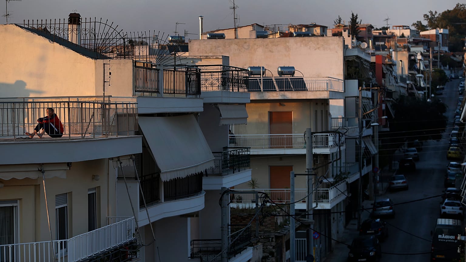 Εικόνα αρχείου- A woman sits on a rooftop in Athens, Saturday, March 21, 2020