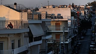 Εικόνα αρχείου- A woman sits on a rooftop in Athens, Saturday, March 21, 2020