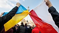 ARQUIVO: Pessoas seguram bandeiras polaca e ucraniana atadas durante uma manifestação em Varsóvia, Polónia, domingo, 23 de fevereiro de 2014