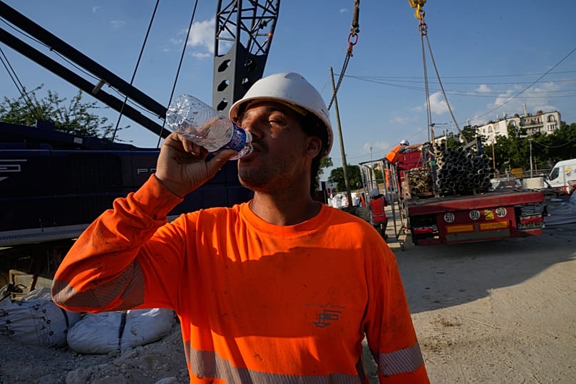 Egy építőmunkás vizet iszik, hogy hidratált maradjon egy hatalmas építkezésen, miközben a hőmérséklet várhatóan rekordmagasságot ér el Párizsban 2026. június 24-én, szerdán.