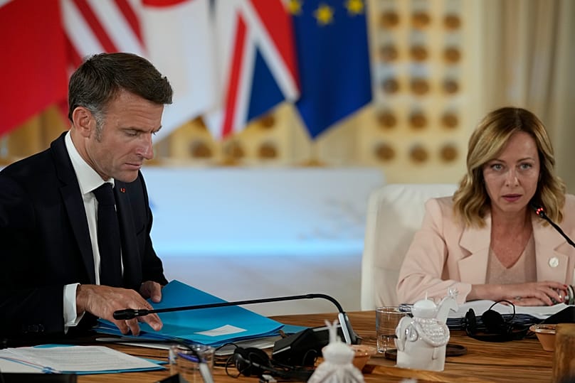 Il presidente francese Emmanuel Macron, a sinistra, ascolta Giorgia Meloni durante il G7 a Borgo Egnazia (13 giugno 2024)