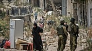 فلسطينيون يجمعون أغراضهم من منازلهم التي تم إخلاؤها في مخيم طولكرم للاجئين في الضفة الغربية بينما يقف جنود إسرائيليون على مقربة، الأربعاء 17 يونيو/حزيران 2026. (صورة من وكالة 