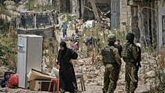 فلسطينيون يجمعون أغراضهم من منازلهم التي تم إخلاؤها في مخيم طولكرم للاجئين في الضفة الغربية بينما يقف جنود إسرائيليون على مقربة، الأربعاء 17 يونيو/حزيران 2026. (صورة من وكالة 
