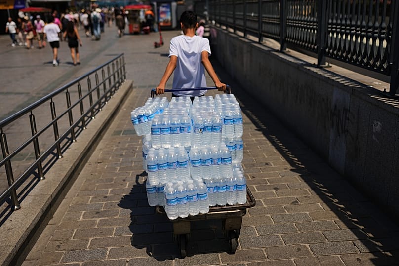شاب يقوم بتوصيل زجاجات مياه بلاستيكية وسط موجة حر في إسطنبول، تركيا، السبت 20 يونيو 2026.