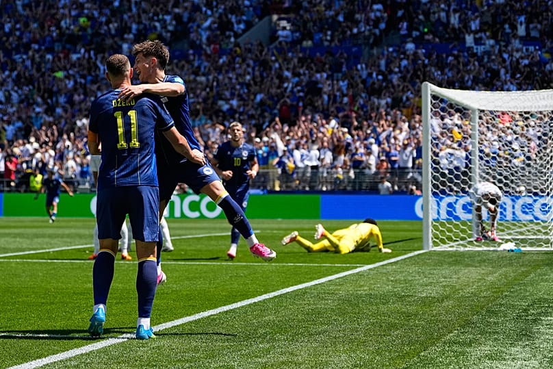 Bosnia's Edin Dzeko celebrates with Esmir Bajraktarevic after Qatar's Sultan Albrake scored an own goal during the World Cup Group B match in Seattle, Wednesday, June 24, 2026