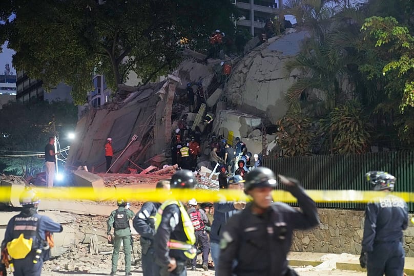 Rescue workers search for survivors at a collapsed building after an earthquake in Caracas, Venezuela, Wednesday, June 24, 2026