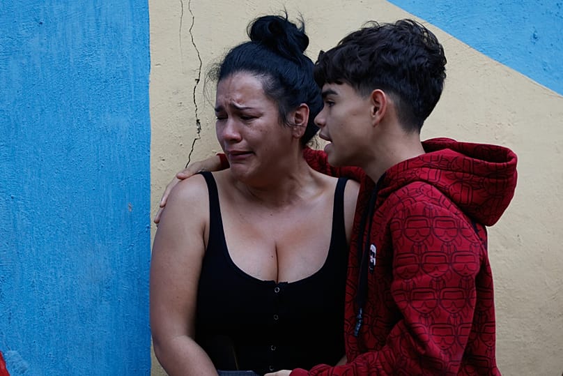 A boy comforts his mother after an earthquake in Caracas, Venezuela, Wednesday, June 24, 2026