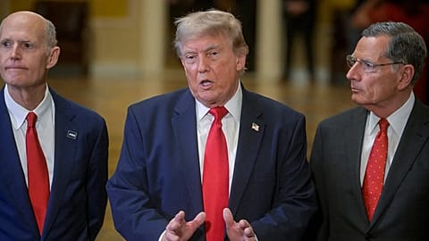 President Donald Trump, center, is joined by Sen. Rick Scott, R-Fla., left, and Sen. John Barrasso, R-Wyo., right, as he departs the Senate Steering Committee Lunch.