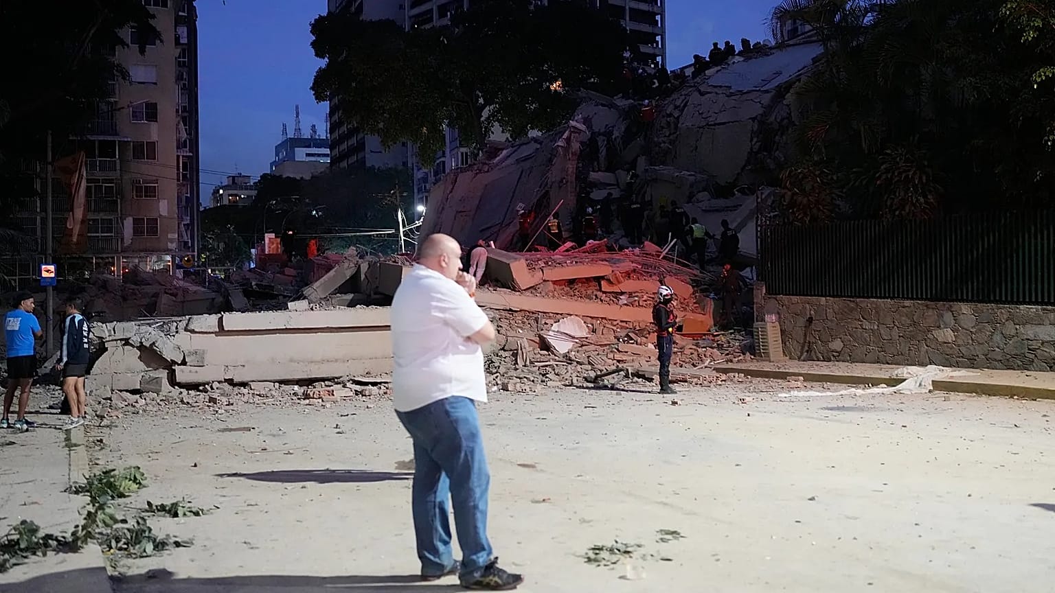 A man stands next to a collapsed building after an earthquake in Caracas, Venezuela, Wednesday, June 24, 2026. 