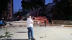 A man stands next to a collapsed building after an earthquake in Caracas, Venezuela, Wednesday, June 24, 2026. 