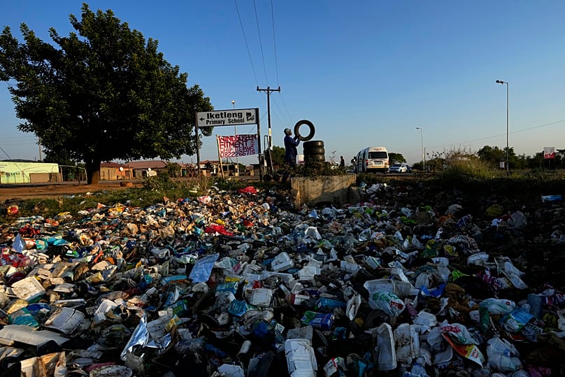 A street vendor places a used tire for sale in Hamanskraal, Pretoria, South Africa, Friday, May 26, 2023. 