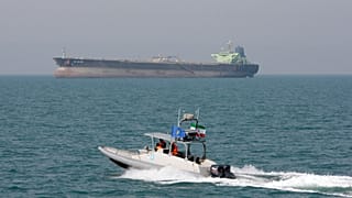 ARCHIVO: Una lancha rápida de la Guardia Revolucionaria iraní navega por el golfo Pérsico mientras al fondo se ve un petrolero, dos de julio de 2012