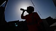 A worker drinks water on a construction site during high temperatures in Boulogne Billancourt, outside Paris, Wednesday, June 24, 2026. 