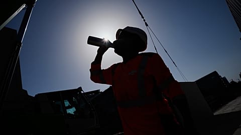 A worker drinks water on a construction site during high temperatures in Boulogne Billancourt, outside Paris, Wednesday, June 24, 2026. 