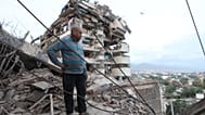 A man stands among the rubble of a collapsed building after an earthquake in La Guaira, Venezuela