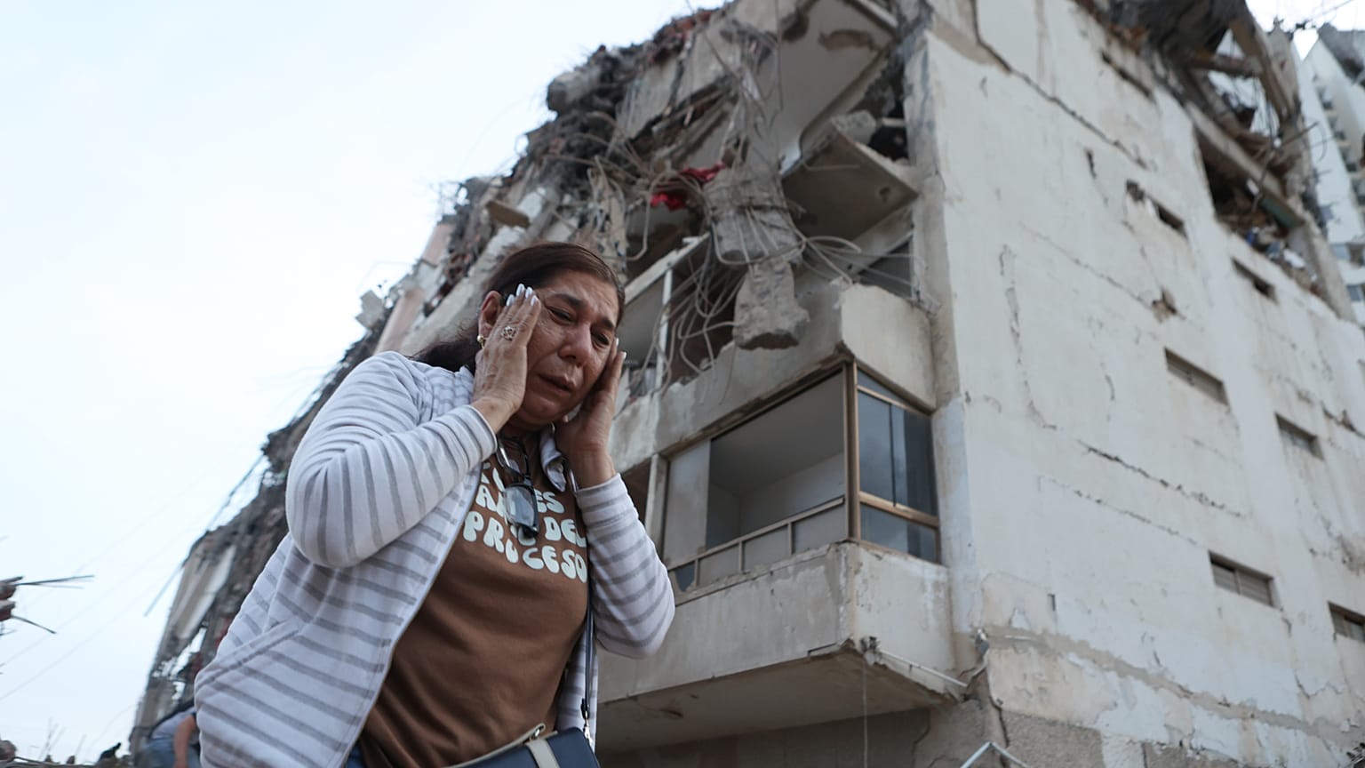Una mujer pasa junto a un edificio dañado durante un terremoto en La Guaira, Venezuela, el jueves 25 de junio de 2026. (AP Photo/Pedro Mattey)