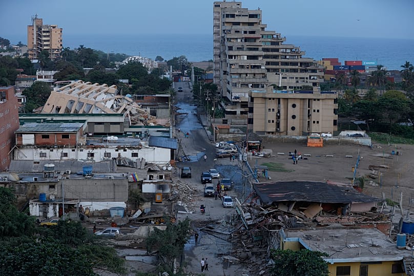 Residentes caminan entre edificios dañados tras un terremoto en La Guaira, Venezuela, el jueves 25 de junio de 2026. (AP Photo/Pedro Mattey)
