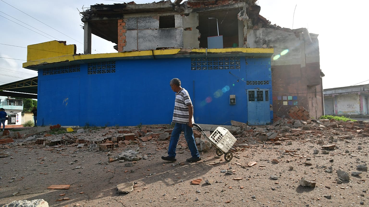 Un hombre pasa junto a una casa dañada en Morón, cerca del epicentro de los dos terremotos que azotaron Venezuela, el 25 de junio de 2026.